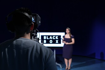 Cameraman recording female presenter of a television programme
