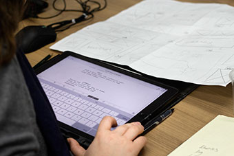 A person at a desk using a tablet