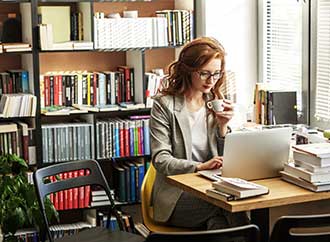 Female university professor preparing for class, using laptop