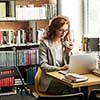 Female university professor preparing for class, using laptop