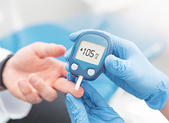 Doctor checking blood sugar level with glucometer. Treatment of diabetes concept.