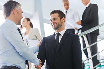 Two people in business attire shacking hands