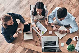 Three people at a desk working together