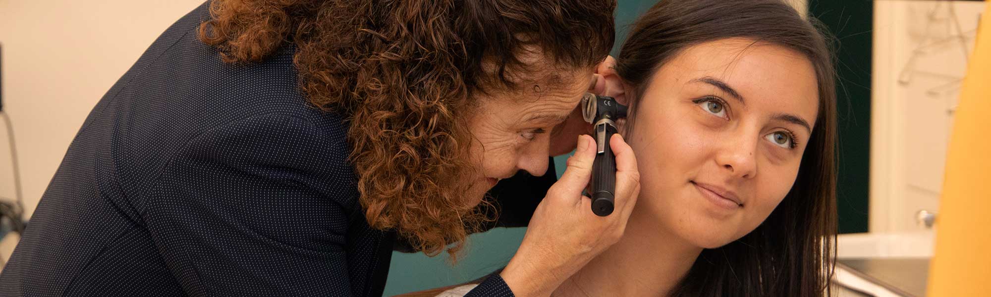 A professional looking into a patient's ear