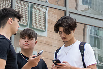 Three students next to EIRL building