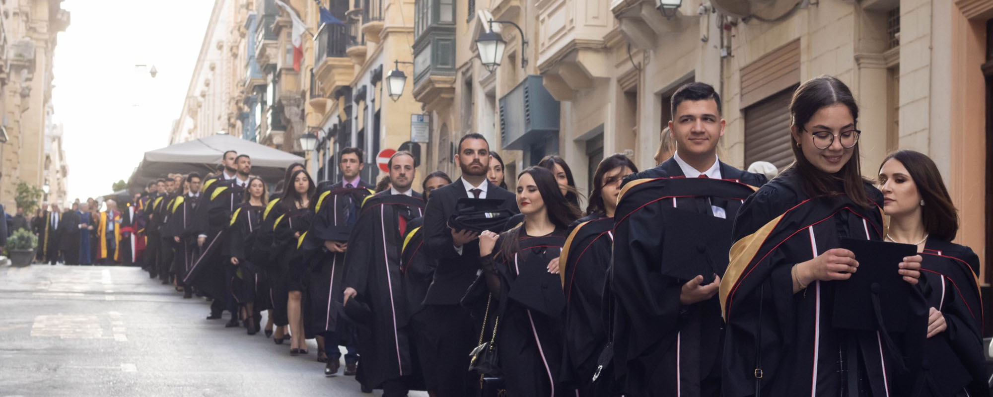 UM graduands walking down a street in Valletta