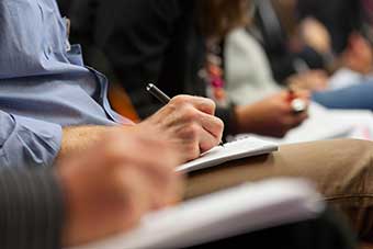 Students writing during a lecture