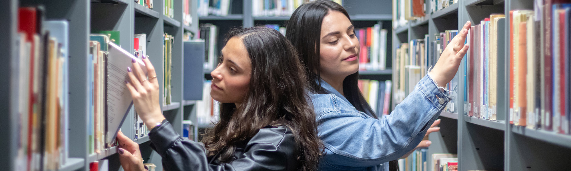 Two students looking for a book in the library